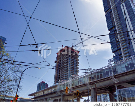 Urban view with power lines crossing blue sky background 136777792