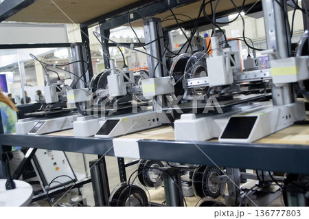 Many 3D printers printing object. 3D printers printing model from molten plastic. 3D printers creating shape from molten plastic flowing out of extruder. New modern 3D Printing additive technologies 136777803