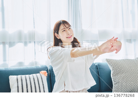 朝の自然光の中で深呼吸をしてリラックスする女性 136778268