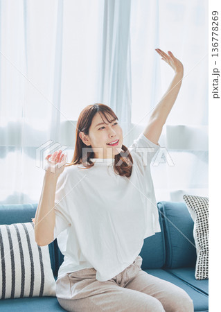 朝の自然光の中で深呼吸をしてリラックスする女性 136778269