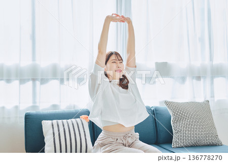 朝の自然光の中で深呼吸をしてリラックスする女性 136778270