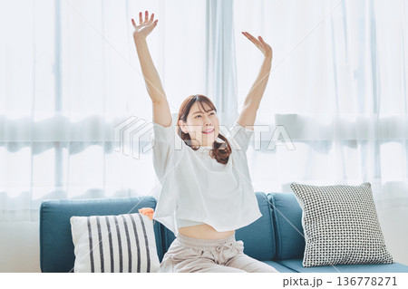 朝の自然光の中で深呼吸をしてリラックスする女性 136778271