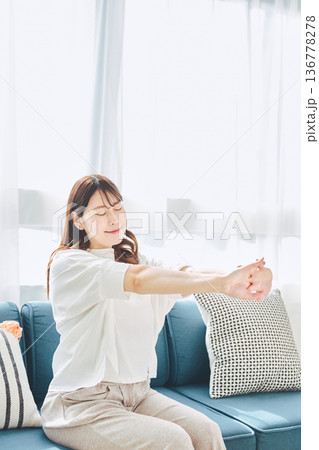 朝の自然光の中で深呼吸をしてリラックスする女性 136778278