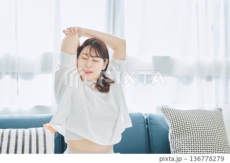 朝の自然光の中で深呼吸をしてリラックスする女性 136778279