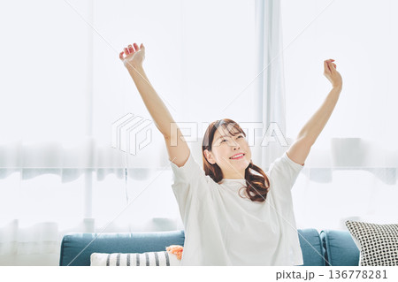 朝の自然光の中で深呼吸をしてリラックスする女性 朝の自然光の中で深呼吸をしてリラックスする女性 136778281