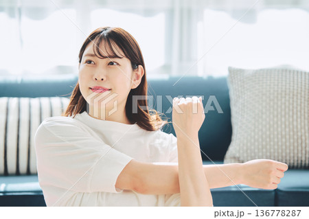 朝の自然光の中で深呼吸をしてリラックスする女性 136778287