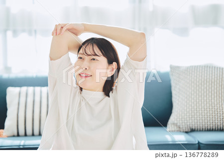 朝の自然光の中で深呼吸をしてリラックスする女性 136778289