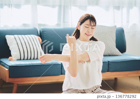 朝の自然光の中で深呼吸をしてリラックスする女性 136778292