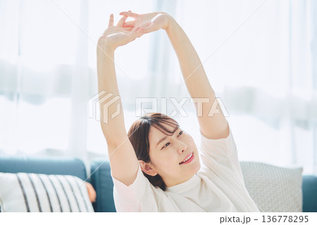 朝の自然光の中で深呼吸をしてリラックスする女性 136778295