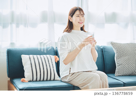 自宅のリビングで水分補給をする健康的な女性 136778659