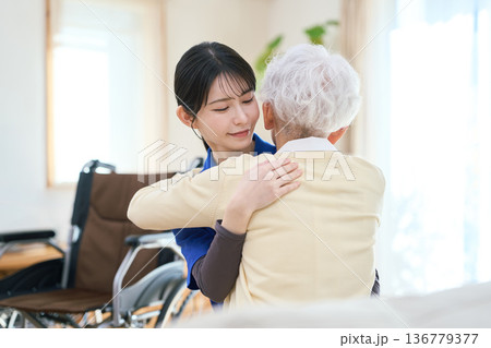訪問介護で移乗介助をするアジア人介護士 136779377