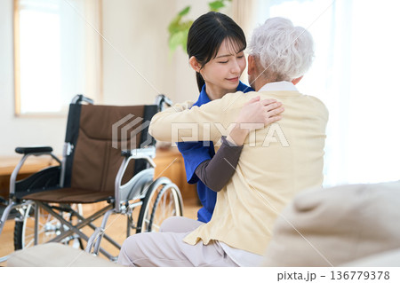 訪問介護で移乗介助をするアジア人介護士 136779378