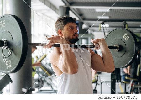 Back squat exercise. Strong man is working out in the gym Back squat exercise. Strong man is working out in the gym 136779575