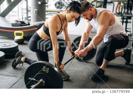 Man and woman are in the gym together Man and woman are in the gym together 136779599