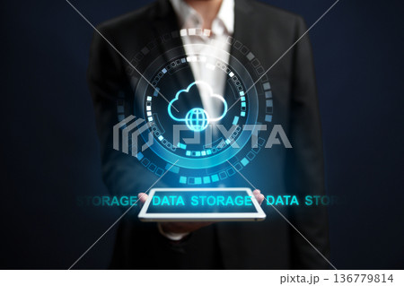 Hand holding tablet with data storage symbol displayed in front of black background Hand holding tablet with data storage symbol displayed in front of black background 136779814