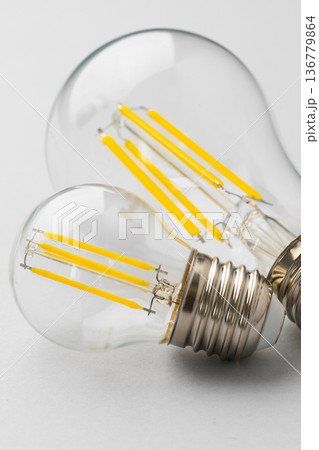 Light bulbs with yellow filaments on a plain background showcase modern design and function Light bulbs with yellow filaments on a plain background showcase modern design and function 136779864