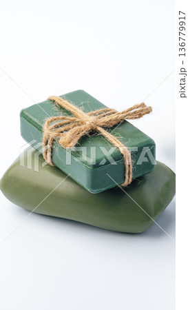 Green soap bars wrapped with twine on a white background with simple design 136779917