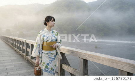 霧がかった朝の渡月橋で佇む浴衣姿の日本人女性 霧がかった朝の渡月橋で佇む浴衣姿の日本人女性 136780178