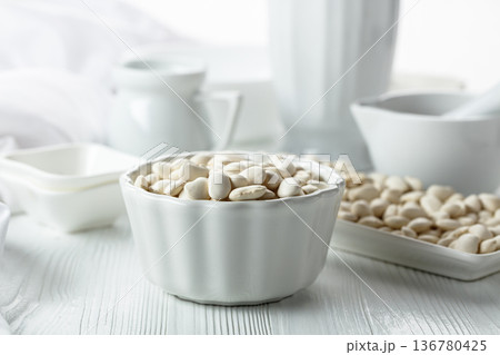 Dried white beans on a white table. 136780425