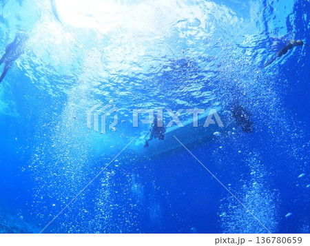 青い海中を漂うダイバーのシルエットと泡　光芒の水中風景 136780659