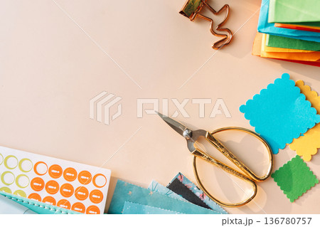 Scissors, planner and colorful paper squares with stickers on pastel background, scrapbooking flat lay Scissors, planner and colorful paper squares with stickers on pastel background, scrapbooking flat lay 136780757
