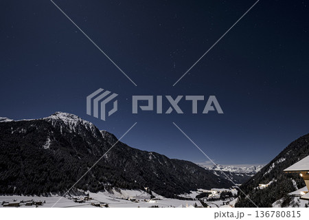 The moment the Milky Way and the moon set over a village in Alps. Glowing stars over mountains at night near Mont-Blanc, Chamonix, France. Orion constellation visible. The moment the Milky Way and the moon set over a village in Alps. Glowing stars over mountains at night near Mont-Blanc, Chamonix, France. Orion constellation visible. 136780815