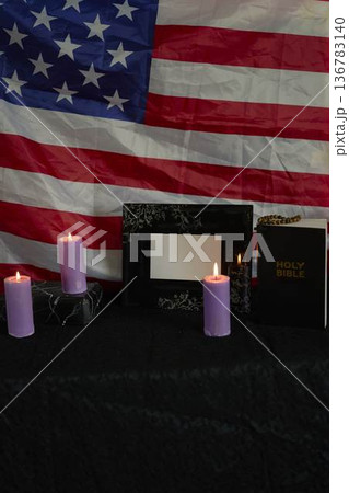 funeral an American hero, photo frame, candles, marble urn for ashes, holy bible and spiritual bracelet with black cross 136783140