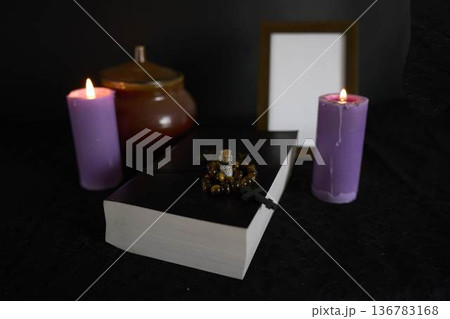 funeral, a photo frame, candles,  urn for ashes, holy bible and spiritual bracelet with black cross  , pendant with ashes 136783168