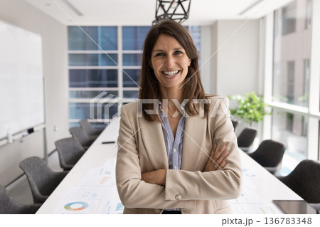Middle-aged 40s confident businesswoman standing in modern conference room Middle-aged 40s confident businesswoman standing in modern conference room 136783348