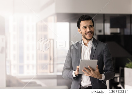Young businessman using modern innovative business tech on tablet Young businessman using modern innovative business tech on tablet 136783354