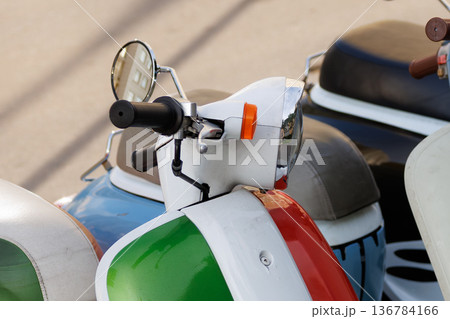 Colorful vintage scooters parked on street in a sunny day showcasing classic design and unique features 136784166