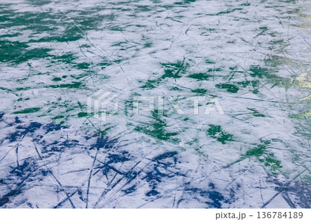 Ice surface showing intricate patterns under soft winter sunlight while awaiting skaters and winter fun 136784189