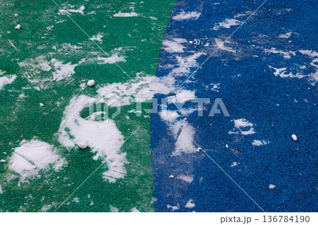 Colorful playground surface with scattered snow in a quiet winter scene Colorful playground surface with scattered snow in a quiet winter scene 136784190