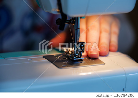 Crafting garments through sewing as fine details come to life in bright, focused light Crafting garments through sewing as fine details come to life in bright, focused light 136784206