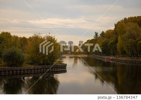 Colorful autumn reflections in a tranquil park by the river during sunset Colorful autumn reflections in a tranquil park by the river during sunset 136784347