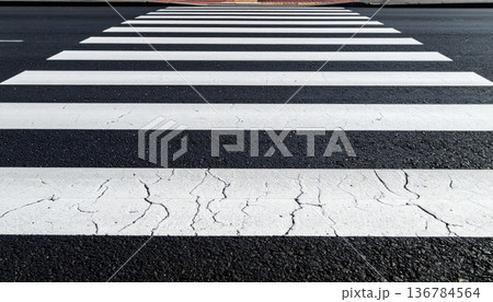 An empty urban asphalt road features white lane lines and a yellow arrow symbol painted on the tarmac to guide city traffic and pedestrian crossing transportation 136784564