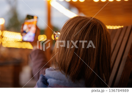 Capturing memories at a cozy evening gathering under sparkling lights Capturing memories at a cozy evening gathering under sparkling lights 136784989