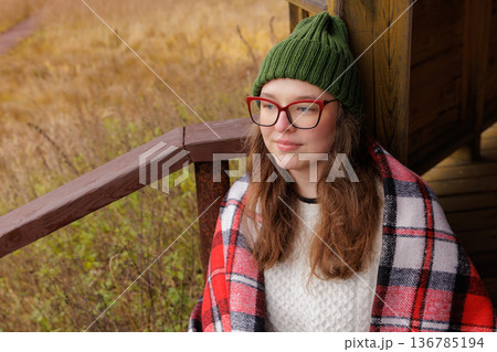Cozy afternoon by the rustic cabin with a warm blanket and a touch of nature's beauty Cozy afternoon by the rustic cabin with a warm blanket and a touch of nature's beauty 136785194