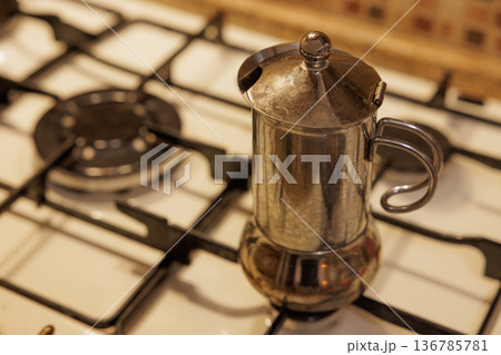 Brewing rich coffee in an elegant moka pot on a cozy stovetop 136785781