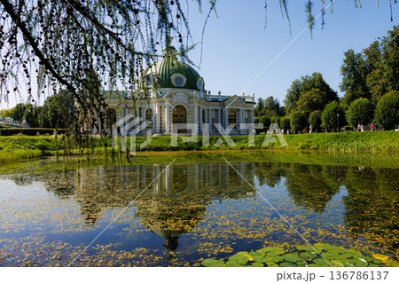 Beautiful palace reflects in calm pond surrounded by lush green trees on a bright sunny day 136786137