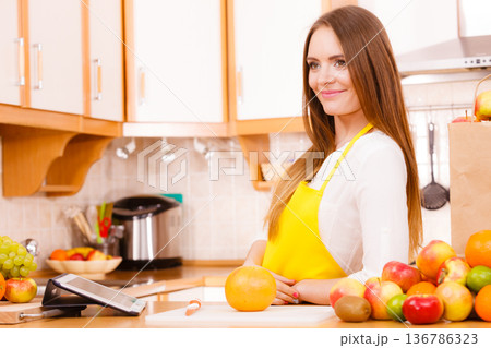 Woman housewife in kitchen using tablet Woman housewife in kitchen using tablet 136786323
