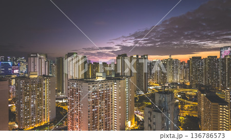 Warm sunset glow lights Kai Tak urban skyline Feb 5 2026 136786573