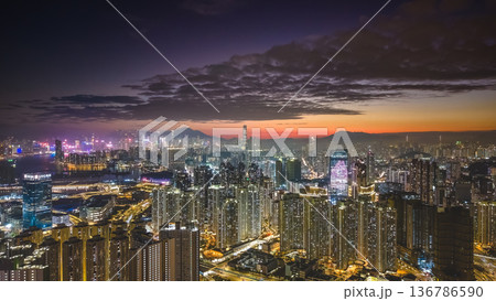 Warm sunset glow lights Kai Tak urban skyline Feb 5 2026 136786590