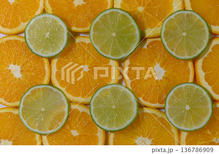 Lime Wedges on Orange Slices Background Lime Wedges on Orange Slices Background 136786909