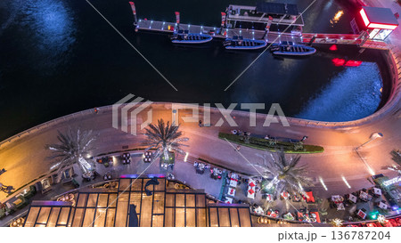 Promenade and canal in Dubai Marina with luxury skyscrapers and yachts around night timelapse, United Arab Emirates 136787204