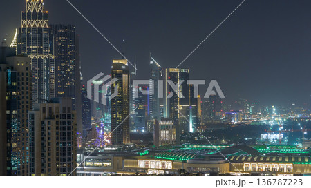 Aerial cityscape timelapse at night with illuminated modern architecture in Downtown of Dubai, United Arab Emirates. Aerial cityscape timelapse at night with illuminated modern architecture in Downtown of Dubai, United Arab Emirates. 136787223