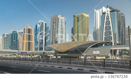 View of Jumeirah lakes towers skyscrapers and metro sration timelapse with traffic on sheikh zayed road. 136787230