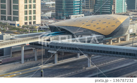 Aerial view of Metro station near Jumeirah lakes towers skyscrapers timelapse with traffic on sheikh zayed road. Aerial view of Metro station near Jumeirah lakes towers skyscrapers timelapse with traffic on sheikh zayed road. 136787232
