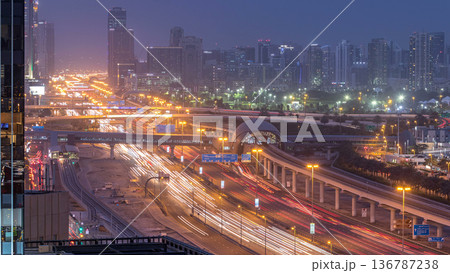 Aerial view of Jumeirah lakes towers skyscrapers day to night timelapse with traffic on sheikh zayed road. Aerial view of Jumeirah lakes towers skyscrapers day to night timelapse with traffic on sheikh zayed road. 136787238