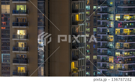 Windows of the multi-storey building of glass and steel lighting inside and moving people within timelapse Windows of the multi-storey building of glass and steel lighting inside and moving people within timelapse 136787282